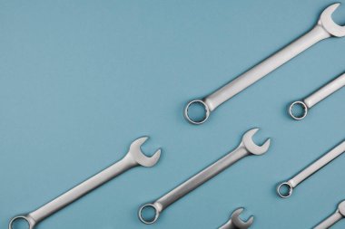 Krom anahtarı mavi arka planda yan yana koyun. Düz konum, üst görünüm, kopyalama alanı ile en düşük bileşim