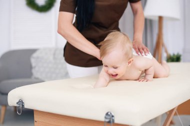 Mutlu bebek profesyonel bayan masöz ile yaptığı masajdan sonra. Sağlık ve tıp kavramı. Nazik ve dostça çocuk doktor.