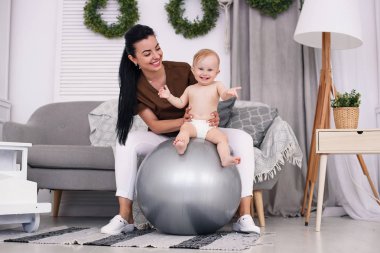 Fizyoterapist ile mutlu bebek Sağlık Odası, jimnastik topu ile yapıyor. Sağlık ve tıp kavramı.