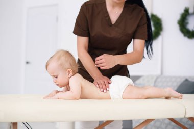 Terapist için modern rahat oda küçük bir bebeğe masaj yapar. Sağlık ve tıp kavramı.