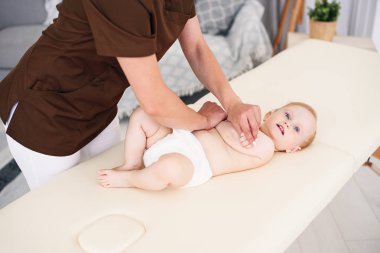 Terapist için modern rahat oda küçük bir bebeğe masaj yapar. Sağlık ve tıp kavramı.