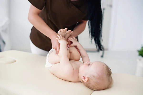 医疗保健和医疗概念 一个专业的女按摩师在现代舒适的房间给一个小宝宝做按摩和体操 — 图库照片