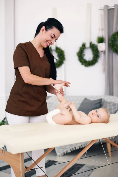医疗保健和医疗概念 一个专业的女按摩师在现代舒适的房间给一个小宝宝做按摩和体操 — 图库照片