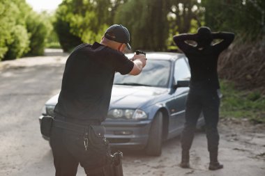 Polis memuru çalıntı araba yakınındaki bir suçlunun hedefliyor. Suçluluk durdurmak.