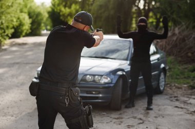 Polis memuru çalıntı araba yakınındaki bir suçlunun hedefliyor. Suçluluk durdurmak.