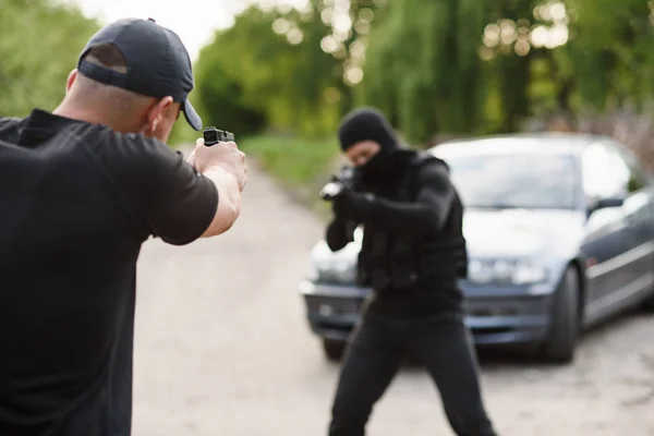 Shootout between a police officer and a offender. Stop Terrorism and Crime. The police officer and the terrorist are aiming each other.