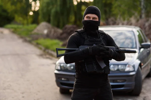 Terorista Černé Masce Automatickou Zbraň Rukou Stojí Pozadí Ukradené Auto — Stock fotografie