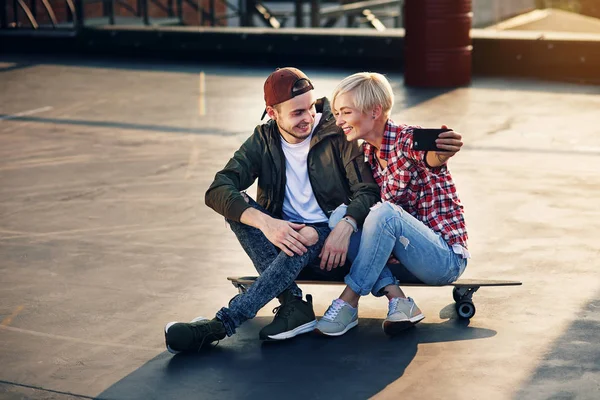 Bonito Casal Jovem Sentado Skate Longboard Telhado Edifício Industrial Fazendo — Fotografia de Stock