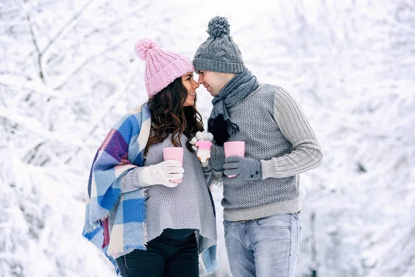 Счастливая Молодая Пара Гуляющая Снежном Парке Розовыми Чашками Чая Розовым — стоковое фото
