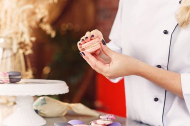 Pudra macarons parçaları birbirleri ile bir krem kullanarak katılır. Macarons yapmak baker eller yukarı kapatın.