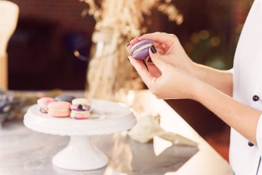 Pudra macarons parçaları birbirleri ile bir krem kullanarak katılır. Macarons yapmak baker eller yukarı kapatın.
