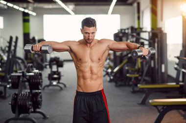 Omuzlarını salonunda eğitim güçlü sağlıklı bir insan. Deltoid kas eğitim izole egzersiz. Modern spor salonunda egzersiz.;