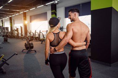 Kas sağlıklı adam ve kız birlikte eğitim sportif arkadaşı. Genç spor çift ayakta salonunda portresi. Arkadan görünüm.