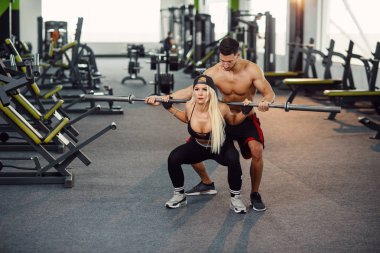 Güzel kız antrenör gözetiminde ağız kavgası yapıyor. Genç bir çift spor salonunda çalışıyor. Çekici kadın ve birlikte eğitim modern spor salonunda yakışıklı kaslı adam.