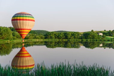 Çok sıcak hava balonu suya yakın göl üzerinde uçan renkli. Doğada balon.