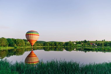 Çok sıcak hava balonu suya yakın göl üzerinde uçan renkli. Doğada balon.