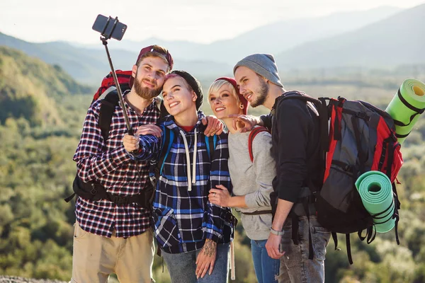 Summer travel concept. Happy friends using paper map near rented car in nature. Happy travelers in mountains on weekend vacation. Beautiful young men and women holding map, exploring location on trip. — Stock Photo, Image