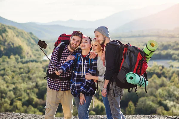 Concepto de viaje de verano. Amigos felices utilizando el mapa de papel cerca de coche alquilado en la naturaleza. Viajeros felices en las montañas en vacaciones de fin de semana. Hermosos hombres y mujeres jóvenes sosteniendo el mapa, explorando la ubicación en el viaje . — Foto de Stock