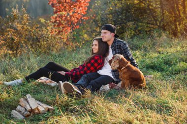 Genç adam onun güzel kız arkadaşı için gitar çalmaya. Bahar park piknik üzerinde dinlenme gitar ile mutlu çift.