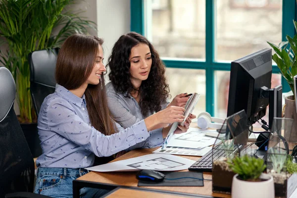 Dos hermosas diseñadoras en la oficina trabajando con muestras de color. Gente creativa o concepto de negocio publicitario . — Foto de Stock