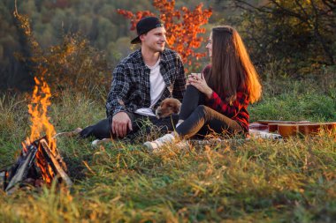 Mutlu çift ile onların komik köpek bahar Park'ın bahçesinde oturan. Genç adam ve kız arkadaşı günbatımında doğanın keyfini.