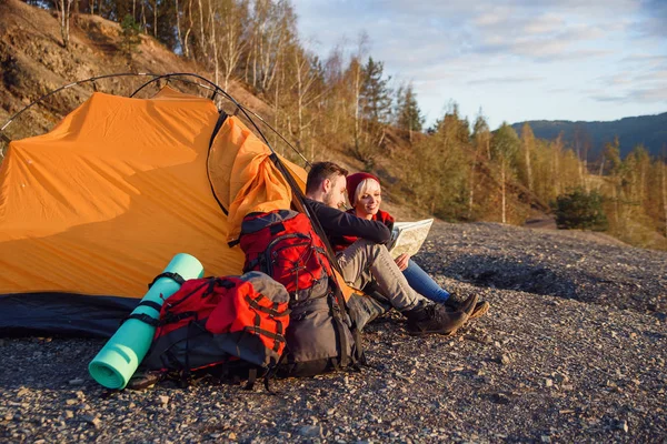 Hipster-Kaukasier-Paar erkundet bei sonnigem Wetter die Karte im Berg, während sie im Zelt sitzen. — Stockfoto