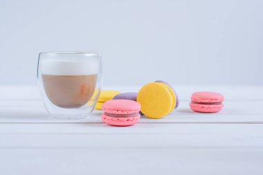 Tatlı lezzetli renkli makarnalar ve kahve fincan.