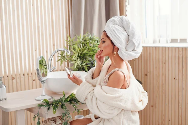 Attravtive girl uses sponge for own makeup in the morning at bathroom. Beauty concept. — Stock Photo, Image