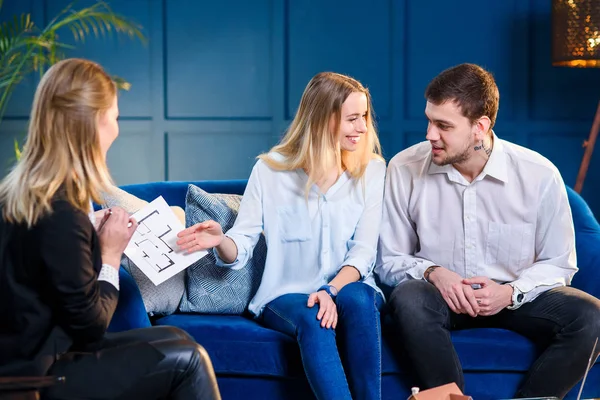 Attractive couple during meeting with realtor, interior designer, decorator. — Stock Photo, Image