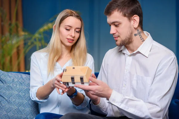 Atrakcyjny kaukaski mężczyzna i kobieta omawiają projekt modelu 3D Maket domu. — Zdjęcie stockowe