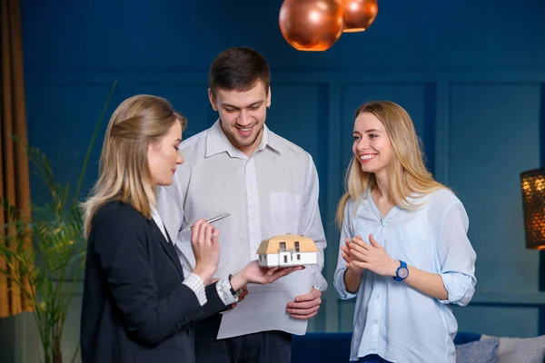 Young professional realtor, designer on the meeting with couple of clients in the stylish blue office. — Stock Photo, Image