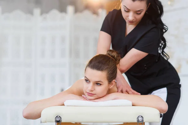 Profesjonalny młody masażysta robi masaż w salonie Spa. — Zdjęcie stockowe