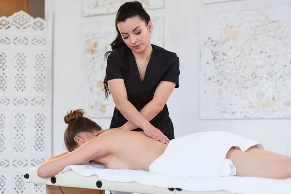 Mulher caucasiana relaxante durante a massagem de tratamento na clínica . — Fotografia de Stock
