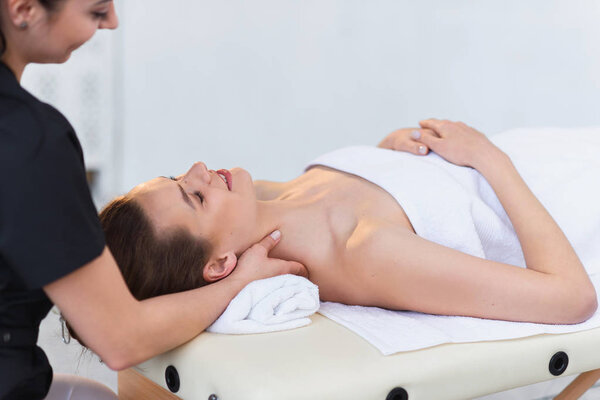 Handsome young woman enjoying spa treatment at salon.