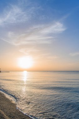 Deniz plajında gündoğumu. Sabah dalgalar olmadan sakin deniz.