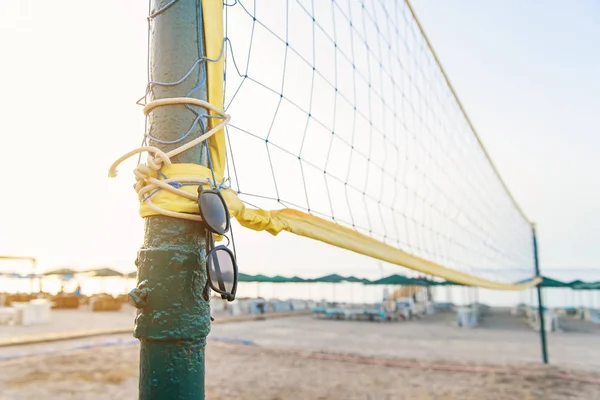 Sol glasögon hänger på volleyboll nätet vid havet stranden. — Stockfoto