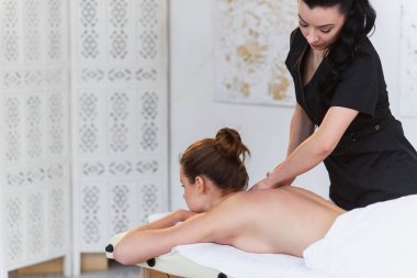 Klinikte tedavi masajı sırasında beyaz kadın rahatlatıcı.