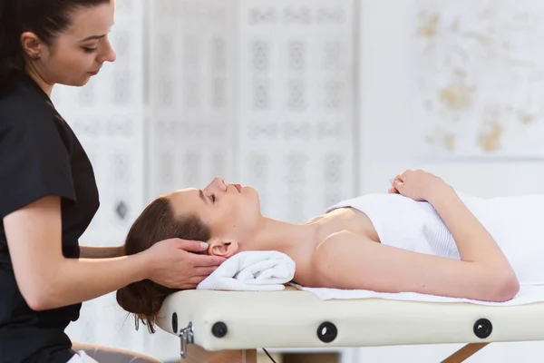 Young professional masseur making massage for sleepy caucasian woman on the white room background. — Stock Photo, Image