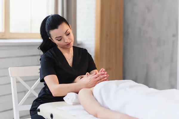 Mujer joven caucásica recibiendo tratamiento de spa en el moderno salón blanco . — Foto de Stock