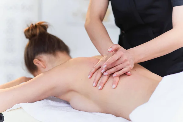 Jovem mulher esporte durante a massagem de tratamento na clínica . — Fotografia de Stock