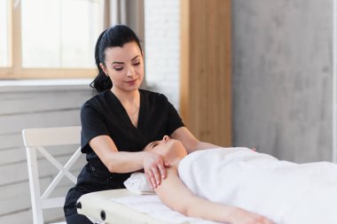 Genç beyaz kadın modern beyaz salonda Spa tedavi alma.