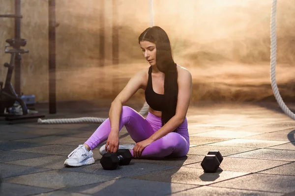 Mujer atractiva cansada descansando después de un largo y duro entrenamiento en el gimnasio . — Foto de Stock