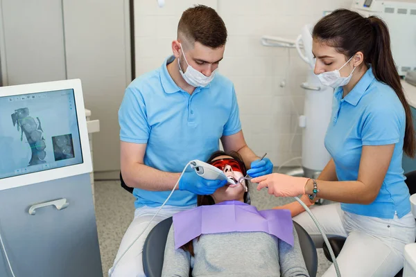 Dentista trabalhando com paciente na clínica moderna. Equipamento moderno em medicina. Dentes conceito de cuidado . — Fotografia de Stock