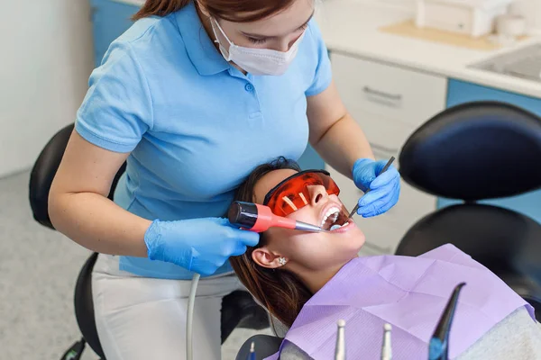 Dentista profissional trabalhando com paciente na clínica moderna — Fotografia de Stock