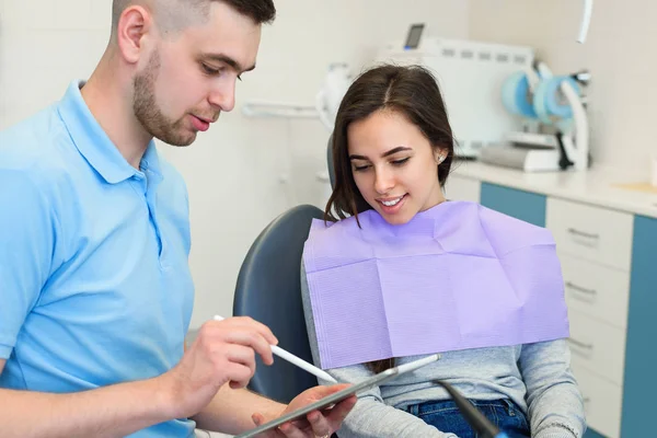 Der Zahnarzt spricht mit einer glücklichen Patientin. — Stockfoto