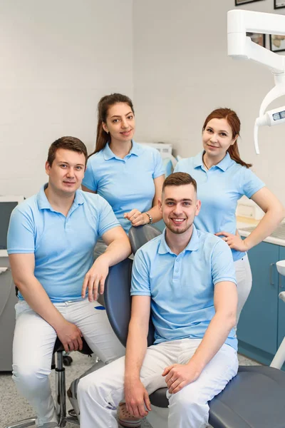 Group of young and happy dental doctors stand near each other at dental clinic. Teamwork and business concept. — Stock Photo, Image