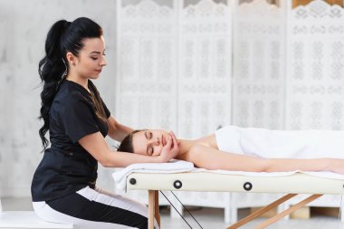 Çekici kadın massaeur Spa arka planda kamera arıyor.