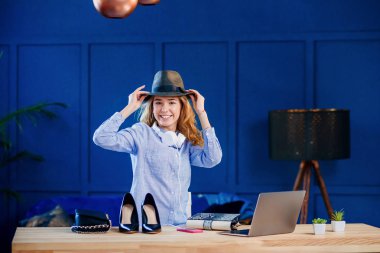 Gülümseyen kadın blogger kayıt video sırasında bir şapka uydurma.