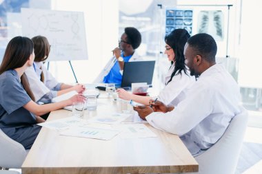 Profesyonel Tıp doktorlarının multiracial grup hastanede konferans odasında bir toplantı var. Genç doktorlar ekibi analiz sonuçları ve hastaların hastalık tarihinin tartışmak.