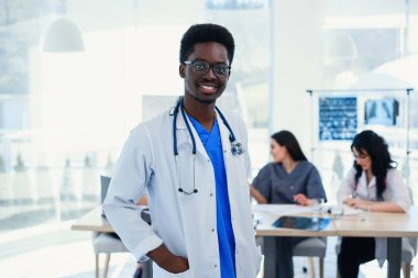 Ciddi Afrikalı Amerikan Doktor portre. Stetoskop ile tıbbi asistan portresi. Hastanede bir tıbbi grup ile erkek doktor.